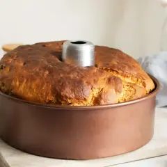 Bizcocho recién horneado en molde, con galletas y un batidor al lado. Parece un bizcocho esponjoso, como una harp sponge.