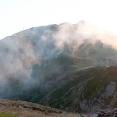 Sentier brumeux sur les hauteurs, un aperçu du tour du Mont-Blanc en 3 jours. Lumière dorée filtrant à travers les nuages.