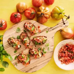 Färska tomater och basilika toppar rostat bröd, en perfekt start för ett enkelt bruschetta recept.
