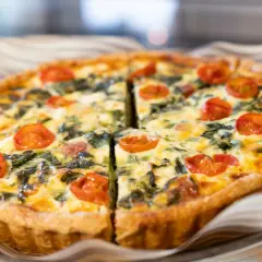 Torta salata con pomodorini e spinaci, perfetta per il tempo di cottura torta salata forno ventilato. Dorata e invitante.
