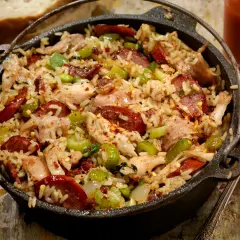 A pyszne jambalaya w żeliwnym garnku, pełne ryżu, kurczaka, kiełbasy i warzyw.