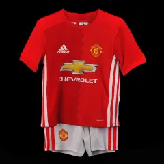 Dziecięcy komplet piłkarski Manchester United: czerwona koszulka i białe spodenki.