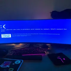 Niebieski ekran Windows 10 z komunikatem "CRITICAL PROCESS DIED". Komputer się zawiesił, a kot obserwuje sytuację z góry.