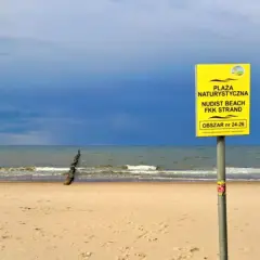 Plaża Chałupy, obszar 24-26, zaprasza na nudystyczny relaks. Spokojne morze i piasek pod błękitnym niebem.