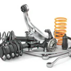 Conjunto de piezas de suspensión automotriz, incluyendo amortiguadores, resortes y un brazo de suspensión en mal estado.