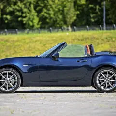 Granatowy roadster z otwartym dachem, widok z boku.