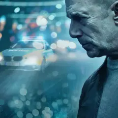 Heino Ferch im düsteren Krimi-Setting. Ein Polizeiauto mit Blaulicht im Regen, die Stimmung ist angespannt. Mehr im Krimi in der Mediathek.