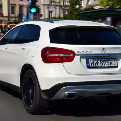Biały Mercedes GLA 200 na polskich tablicach rejestracyjnych jedzie ulicą miasta.
