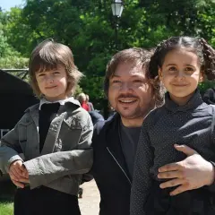Mietek Szczęśniak z żoną i dziećmi w parku.