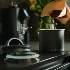 Frische Kaffeebohnen werden in einen Airscape Behälter geschüttet, bereit für die perfekte Kaffee-Infusion.