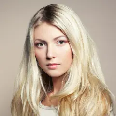 Piękna blondynka z długimi, falowanymi włosami. Poznaj sekrety, jak dbać o blond włosy, by były zdrowe i lśniące.