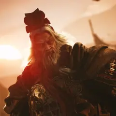 Starzec z siwą brodą i w tradycyjnym nakryciu głowy, dzierżący miecz legend. W tle zachodzące słońce i flagi.