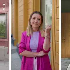 Różowe kolory ścian w łazience, kobieta w fuksjowej marynarce i nowoczesne wnętrze z drewnianymi panelami.