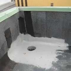 Nowy dach z papy z uszczelnieniem z elastomeru. Widać otwór odpływowy i zieloną attykę.