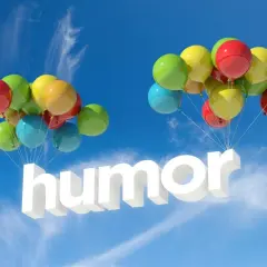 Färgglada ballonger bär upp ordet "humor" i luften. En härlig skrift med humor som svävar mot en blå himmel.