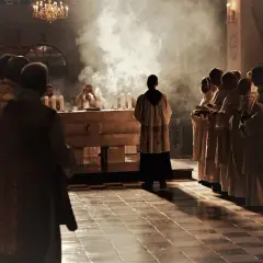 Kiedy jest modlitwa wiernych na mszy, kapłani w szatach stoją w dymie kadzidła przed ołtarzem.