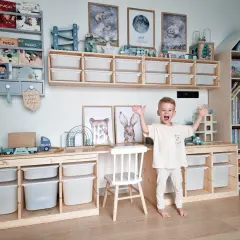 Radosny chłopiec w pokoju dla dziewczynki 4 latka. Wszędzie zabawki i książki, idealne miejsce do zabawy.