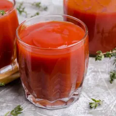 Gęsty, czerwony sok pomidorowy w szklankach, idealny na orzeźwienie. Gałązki tymianku dodają aromatu.