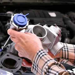 Mechanik pokazuje turbosprężarkę, element kluczowy dla czujnika ciśnienia doładowania. Gdzie się znajduje? W silniku!