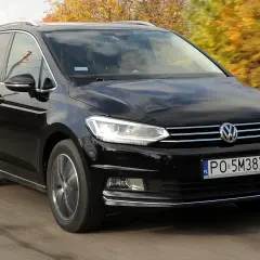 Czarny Volkswagen Touran 1.9 TDI 105 KM szarpie przy przyspieszaniu, jadąc po drodze wśród jesiennych drzew.