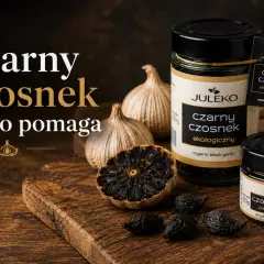 Czarny czosnek w słoikach i na desce, obok świeżych główek. Poznaj jego właściwości!