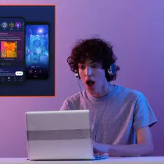 Chłopak z słuchawkami na uszach zszokowany patrzy na ekran laptopa, na którym widać aplikację muzyczną przypominającą Napster.