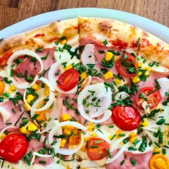 Pyszna pizza 32 cm na ile osób? Ta z szynką, pomidorkami, kukurydzą i cebulą z pewnością zadowoli 2-3 głodomorów.