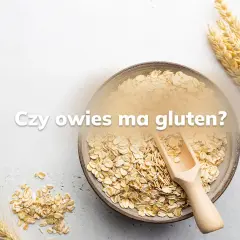 Miseczka płatków owsianych i kłosy zbóż. Pytanie "Czy owies ma gluten?" sugeruje dyskusję o jego zawartości.