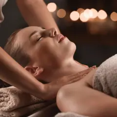Relaksacyjny masaż karku i ramion w **day spa Szczecin**. Kobieta z zamkniętymi oczami odpręża się pod dotykiem masażystki.