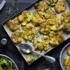 Ugnsbakade, krossade potatisar med ost och örter, serverade med korv och en fräsch sallad. En härlig måltid!