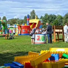 Kolorowe dmuchańce i plac zabaw tworzą wspaniałe ustka atrakcje dla dzieci. Rodziny cieszą się słońcem i zabawą.
