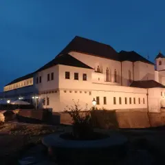 Brno zamek nocą, oświetlony, z wieżą i murami obronnymi.