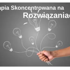 Dłoń trzyma pęk żarówek symbolizujących podejście skoncentrowane na rozwiązaniach i nowe pomysły.