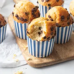 Muffin in friggitrice ad aria con gocce di cioccolato, uno è stato morso rivelando un interno soffice e goloso.