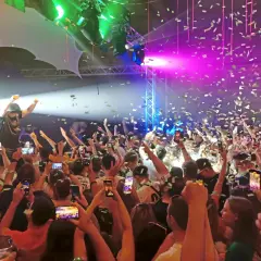 Konfetti regnet auf eine jubelnde Menge bei einem Konzert. Ein DJ steht auf der Bühne, während die Leute ihre Handys hochhalten, um den Moment beim Altdorfer Wasen festzuhalten.