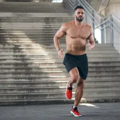 Ein Mann joggt eine Treppe hoch. Beim Joggen werden viele Muskeln trainiert, besonders die Beinmuskulatur.
