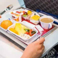 Un pasto aereo con omelette, verdure, pane e caffè. Si può portare cibo in aereo, e questo è un esempio di come viene servito.