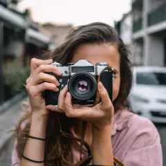 Dziewczyna z aparatem, idealna do kursu fotografii dla początkujących.
