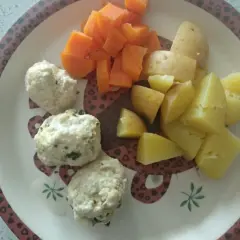 Na talerzu ułożone są delikatne pulpety dla niemowlaka, obok nich kawałki gotowanych ziemniaków i marchewki.
