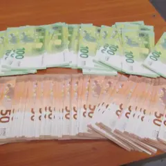 Duże stosy banknotów 100 i 50 euro leżą na drewnianym stole. Zastanawiasz się, ile gotówki można przewozić samolotem?