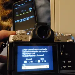 Aktualizacja oprogramowania aparatu Nikon z telefonu. Ekran aparatu pokazuje komunikat o pobraniu pliku aktualizacji i pytanie, czy chcesz zaktualizować oprogramowanie.