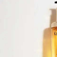 Lyxig flaska med Kérastase Elixir Ultime olja i håret. Ger glans och näring.