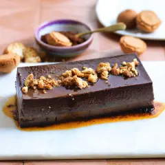 Bonet piemontese al cioccolato, lucido e cremoso, guarnito con briciole croccanti e salsa caramello.