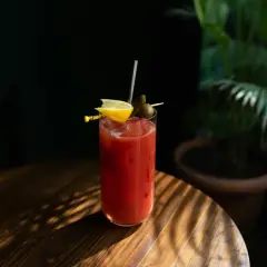 Kieliszek Bloody Mary z cytryną i oliwką. Ciekawa bloody mary historia tego drinka zaczyna się w latach 20. XX wieku.