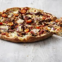 Pizza Hut ciasto San Francisco z pomidorkami, cebulą i serem. Pyszna, gorąca pizza na drewnianym blacie.
