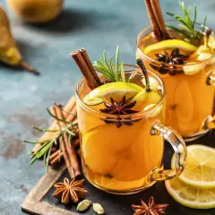 Due bicchieri di hot toddy ricetta con cannella, anice stellato, limone e pera. Perfetto per scaldarsi.