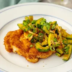 Krispig panerad schnitzel med en fräsch gurksallad toppad med sesamfrön och salladslök. En härlig kombination av texturer och smaker.