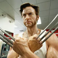 Wolverine, avec sa barbe distinctive et ses griffes rétractées, pose dans une salle de sport.