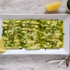 Delicioso plato de boquerones veganos, finas láminas de calabacín marinado con ajo, perejil y limón.
