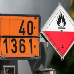 Pomarańczowe tablice z numerami 40 i 1361 oraz biało-czerwony znak ostrzegawczy z płomieniem i cyfrą 4, informujące o zagrożeniu. Taryfikator kar ADR.